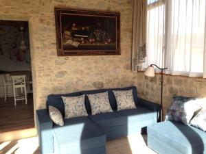 CapannucciaFAETOLE typical Tuscan country house near FLORENCE的客厅配有蓝色的沙发和墙上的绘画