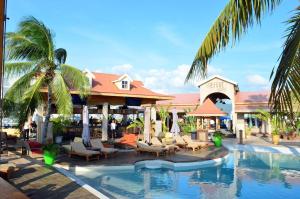 马霍礁Sunset Beach Condo - Luxury 1BR Suite next to The Morgan Resort的一个带椅子和棕榈树的游泳池的度假酒店