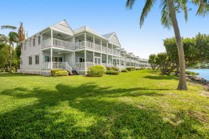 鸭礁岛Palm Breeze的草坪上种有棕榈树的大型白色房屋