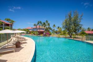 勒弗朗索瓦Villa Maorie 1 chambre avec piscine privée的度假村的游泳池,配有椅子和遮阳伞