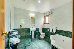 汉默温泉哈罗盖特花园汽车旅馆的带浴缸、卫生间和盥洗盆的浴室