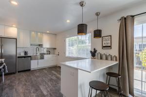 East Palo AltoMarbella Lane - Neat and Cozy Modern Home的白色的厨房,配有一个柜台和两个凳子