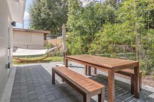 奥兰多Luxury Tiny Home 2 Miles from Downtown Orlando的庭院设有一张木桌和长凳,配有吊床