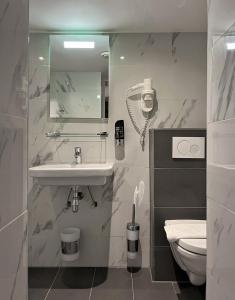 阿姆斯特丹Facade Hotel Amsterdam的白色的浴室设有水槽和卫生间。