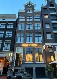 阿姆斯特丹Facade Hotel Amsterdam的城市街道上的一座建筑,有商店