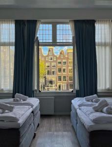 阿姆斯特丹Facade Hotel Amsterdam的一间卧室设有两张床和大窗户