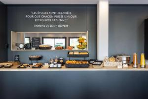 伊斯内斯Best Western St Exupery Bordeaux Ouest的面包柜台提供蛋糕和糕点