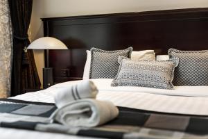沃加沃加沃加沃加国际酒店的一间卧室配有一张带黑色床头板和枕头的床。