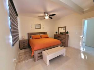 佩尼亚斯科港Earthy 2 Story Beach House!的一间卧室配有一张床和吊扇