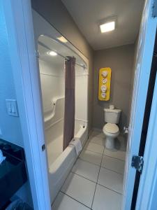 丹顿Motel 6 Denton, TX - UNT的带浴缸、卫生间和淋浴的浴室。