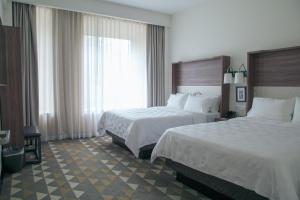 底拉斯卡拉Holiday Inn Tlaxcala, an IHG Hotel的酒店客房设有两张床和窗户。
