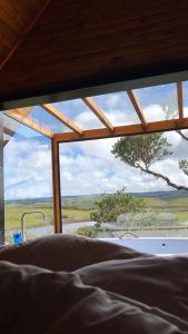 圣若泽-杜斯奥森蒂斯Morada Alto Das Nuvens的一间卧室设有窗户,享有田野美景