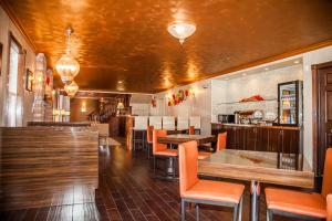 卡纳布大峡谷精品酒店 - 峡谷集团的一间设有橙色桌椅的餐厅和一间酒吧