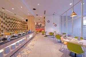 三宝垄KHAS Semarang Hotel的一间带桌椅的餐厅以及一间自助餐
