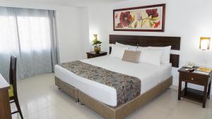 圣玛尔塔Hotel Arhuaco Rodadero的一间卧室配有一张大床和一部电话