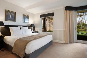 肯图巴Echoes Boutique Hotel & Restaurant Blue Mountains的一间卧室设有一张大床和一个窗户。
