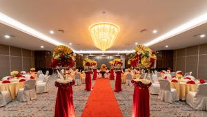 怡保Travelodge Ipoh的一个带桌椅和红地毯的宴会厅