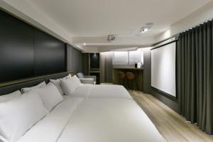 台中市暮云商旅的卧室设有一张白色大床和一扇窗户。