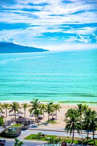 岘港Central Beach Hotel的享有棕榈树海滩和大海的景色