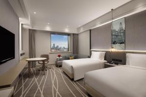 上海上海南新雅皇冠假日酒店的酒店客房设有两张床和一台平面电视。
