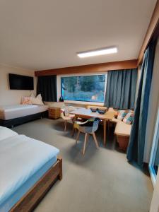 比伯维尔Alpinum Hostel的一间卧室配有书桌、一张床和一张桌子