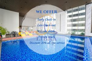 芽庄芽庄利布拉酒店的游泳池配有标志,可阅读,酒店提供提早入住和延迟退房服务。