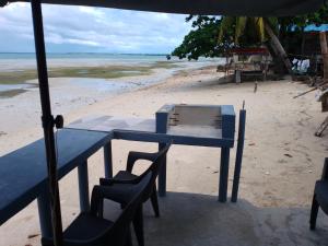 DaanbantayanLittle Sanity Beach house的海滩上的蓝色桌椅