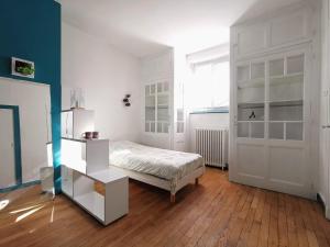 圣瑞尼安Chambres d'hôtes La Maison Blanche的卧室配有床和白色门