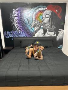 芭堤雅市中心The Green Spot的一个小女孩躺在壁画前面的床上