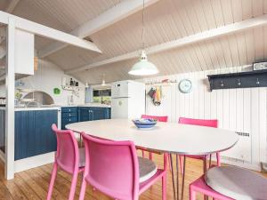 Brunshuse6 person holiday home in Haarby的厨房配有白色的桌子和粉红色的椅子