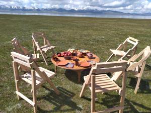 科奇科尔Son-Kul Northen yurt camp的三把椅子和一张桌子,上面有果实