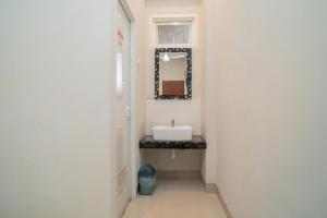 巴图Urbanview Hotel Bubusini Batu by RedDoorz的一间带水槽和镜子的浴室