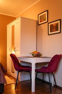 戈斯拉尔Apartment Serenade am Zwinger的一张桌子,上面有两把椅子和一碗水果