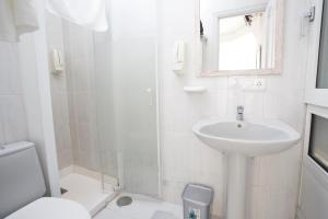 拉科鲁尼亚Hostal Costa Coruña的一间带水槽、卫生间和镜子的浴室