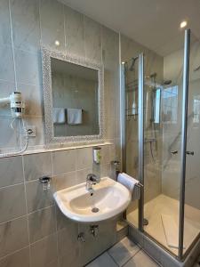 勒沃库森阿尔卡德酒店的一间带水槽和淋浴的浴室