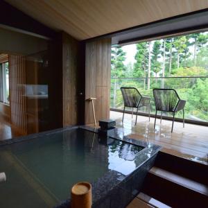 箱根Hakone Gora Byakudan的客厅配有大型玻璃桌和椅子