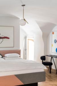 格拉茨Kai 36 - Hotel zwischen Fels und Fluss的白色卧室配有床和书桌
