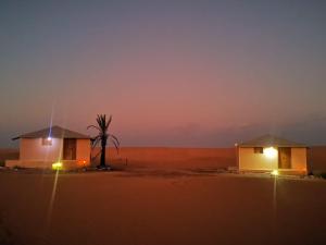 ḨawīyahSafari Dunes Camp的沙漠中两所小房子