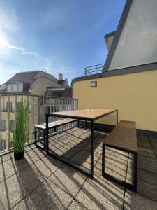 德累斯顿Maisonette-Apartment An der Frauenkirche的阳台的天井配有桌子和长凳