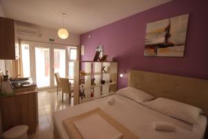 耶泽拉Apartment Antonio的卧室配有白色的床和紫色墙壁