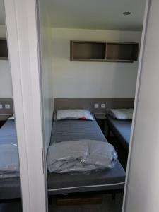滨海皮里亚克Mobilhome 6/8 personnes Piriac sur Mer的一间小房间,内设两张床