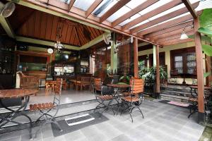 日惹Ndalem Maharani Guest House的餐厅内带桌椅的庭院