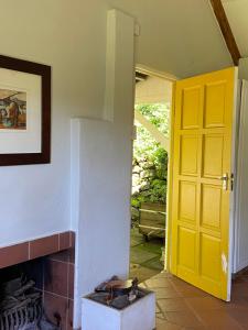 Curryʼs PostYellowwoods Farm - POOL COTTAGE (self-catering)的一间设有黄色门和壁炉的客房
