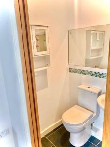 The Cart House的浴室配有白色卫生间和盥洗盆。