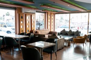 吉达Elite Al Hamra - Al Cornich的餐厅配有沙发、桌子和窗户