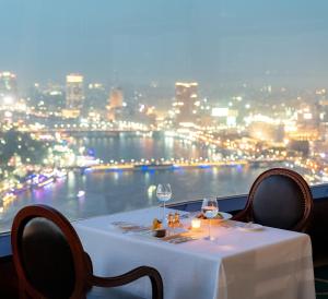 开罗尼罗河大厦酒店的一张桌子和两杯酒,享有城市美景
