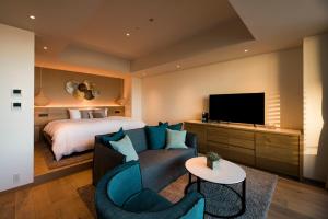 逗子市MALIBU HOTEL的酒店客房配有床、沙发和电视。