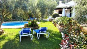 埃尔乔罗El Chorro Villas Casa Rosaleda的一个带两把椅子的庭院和一个游泳池