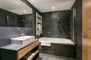 库哈台All-Suite Resort Kühtai的浴室配有盥洗盆和浴缸。