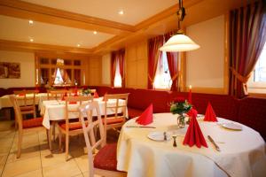 Rudersberg索奈酒店及餐厅的餐厅设有红色餐巾和红色蜡烛桌